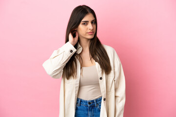 Wall Mural - Young caucasian woman isolated on pink background having doubts