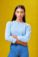 Poster - Arms crossed, fashion and student with portrait of woman in studio for future, pride and serious. Youth, confident and college with Indian person on yellow background for learning and trendy style