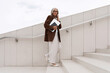 © Ivan Traimak - a gray-haired middle-aged woman with a bob hairstyle dressed in a jacket and trousers walks around the city against the backdrop of a business center and offices