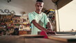Young carpenter using saw machine to slice wood at workshop. Focused apprentice at carpentry artisan craftmanship store