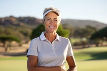 Portrait Of A Smiling Mature Woman Standing With Arms Crossed On Golf Course