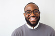 © ImageHeaven - A beaming Black man with glasses, photographed against a simple white background.