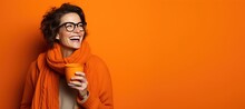 Young Woman In A Scarf Drinking Cup Of Coffee On A Orange Banner With Space For Copy