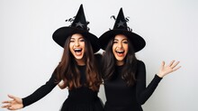Two Happy Young Women In Black Witch Halloween Costumes On Party Over White Background