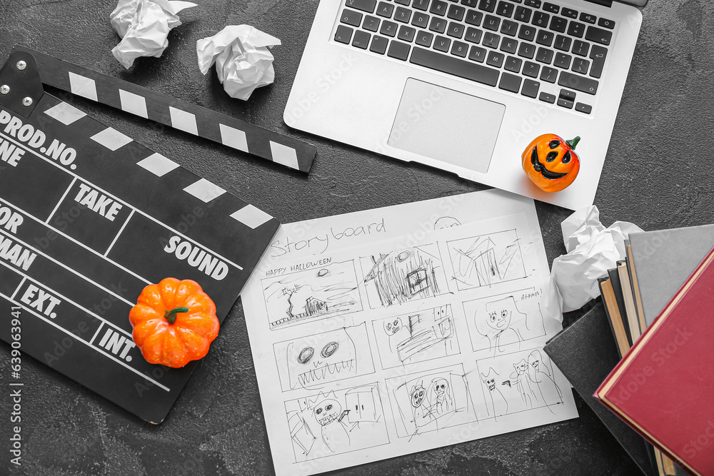 Laptop with clapperboard, storyboard and pumpkins on grunge grey background. Halloween celebration