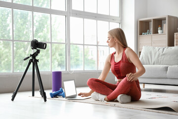 Poster - Beautiful young sport blogger recording video while training with roller and dumbbells at home