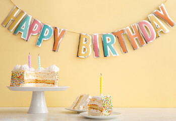 Wall Mural - Party garland and stand with yummy Birthday cake on table near beige wall