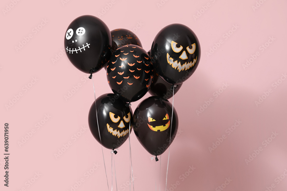 Different black Halloween balloons on pink background
