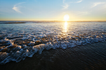 Atlantic ocean sunset with surging waves at Fonte da Telha beach, Costa da Caparica, Portugal