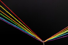 Micro Of Needle With Rainbow Coloured Threads And Copy Space On Black Background