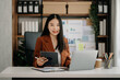© Nuttapong punna - Business woman using tablet and laptop for doing math finance on an office desk, tax, report, accounting, statistics, and analytical research concept