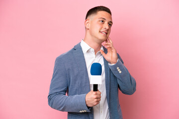 Wall Mural - Young brazilian presenter man isolated on pink background thinking an idea while looking up