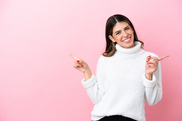 Wall Mural - Young Italian woman isolated on pink background pointing finger to the laterals and happy