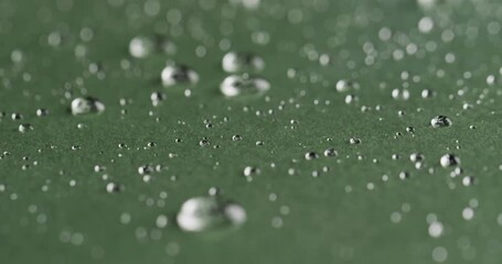 Poster - Micro video of close up of water drops with copy space on green background