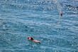Młoda dziewczyna w stringach płynie na materacu po morzu. 