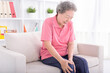Asian senior woman sitting on sofa and having the joint pain
