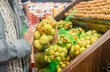 Woman choosing fresh packed fruits at the supermarket. Customer buying food at grocery shops.