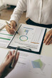 © ArLawKa - Business team meeting using calculator Working with laptop and charts and analyzing business strategy Financial statistics sitting at the table in the financial office in vertical view