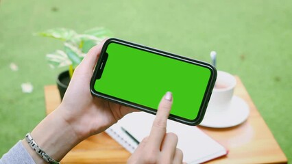 Poster - Woman with Green Screen Chroma Key Smartphone in Cafe. Asian Person using Internet, Social Media, Online Shopping with Mobile Phone Device. Focus on 
 Display.