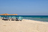 Fototapeta Morze - Sunbeds with umbrella on sandy beach of Marmari. The Greek island of Kos