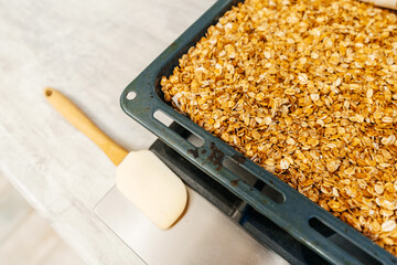 cooking granola at home. Hercules grains in a metal sheet for the oven. drying granola at home