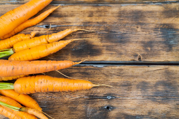 Wall Mural - young carrots on an old wooden background top view