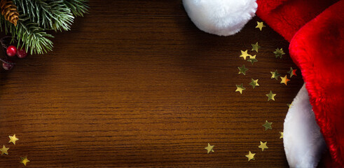 Wall Mural - christmas banner. christmas tree branch and santa hat on wooden background. wide xmas banner mockup,