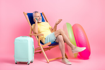 Poster - Full body photo of pensioner man sitting his sunbed talking conversation phone call waiting airport isolated on pink color background