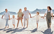 © Talia Mdlungu/peopleimages.com - Happy, walking and big family holding hands at the beach on vacation, holiday or adventure together. Bonding, fun and children with parents and grandparents by the ocean for fresh air on weekend trip