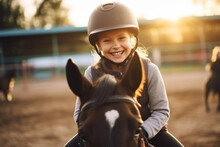 Happy Girl Kid At Equitation Lesson Looking At Camera While Riding A Horse, Wearing Horseriding Helmet