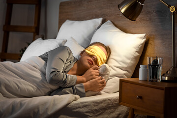 Wall Mural - Young woman with mask sleeping in bed at night