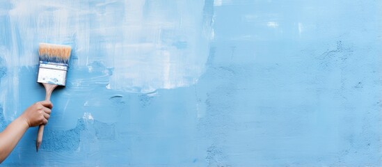 Aufkleber - Someone in a blue glove paints on a blue wall with a brush