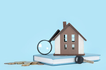 Poster - House figure with magnifier, key, coins and book on blue background. Concept of buying real estate