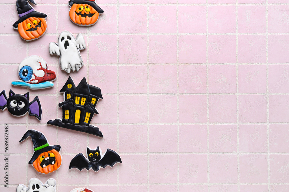 Different tasty cookies for Halloween celebration on pink tile background