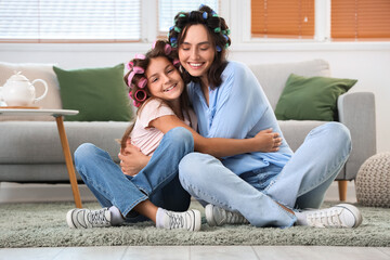 Sticker - Little girl and her mother with hair curlers hugging at home