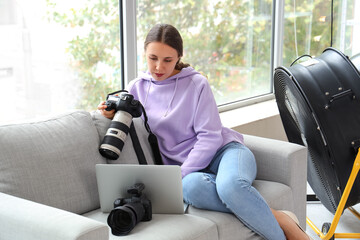 Wall Mural - Female photographer with camera working in studio