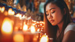 candles, sadness and crying, asian slim young adult woman, 30s 30s, wearing green shirt, standing in a church and can't believe it or desperate, feelings and emotions