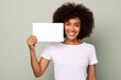 © Martin - female wearing white tshirt holding up blank card for mock ups on light green background