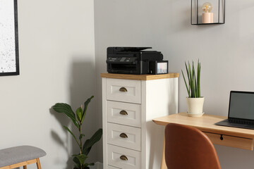 Canvas Print - Modern printer on chest of drawers near wooden table indoors