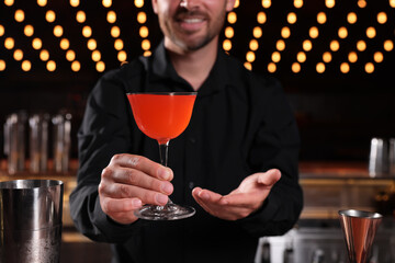 Poster - Bartender with fresh alcoholic cocktail in bar, closeup