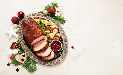 Wall Mural - Roasted sliced Christmas ham on plate with vegetables, festive decoration.