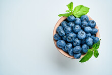 Blueberries In A Ceramic Bowl On A Light Background. View From Above