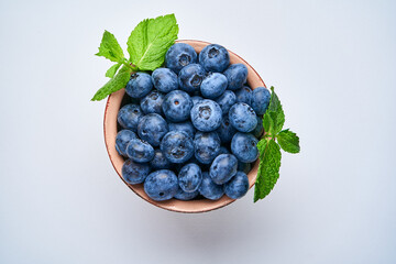 Wall Mural - Blueberries in a ceramic bowl on a light background. View from above