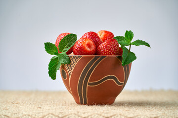 Wall Mural - strawberries in a ceramic bowl on a light background