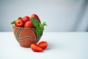 Wall Mural - strawberries in a ceramic bowl on a light background
