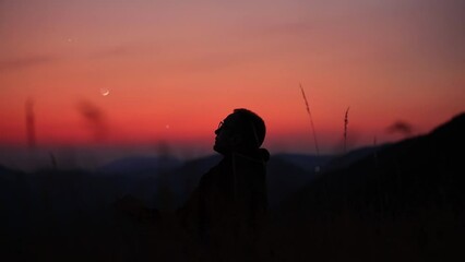 Wall Mural - man looking at the starry skies, crescent moon and shooting star in blue hour twilight time.
