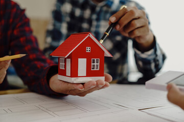 3rd male engineer designing house structure on table in office