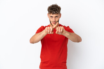 Young caucasian handsome man isolated on white background making stop gesture with her hand to stop an act