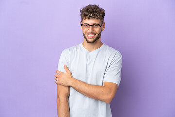 Wall Mural - Delivery caucasian man isolated on purple background laughing