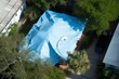 Overhead view of damaged house roof covered with tarps after Hurricane Ian. Generative AI